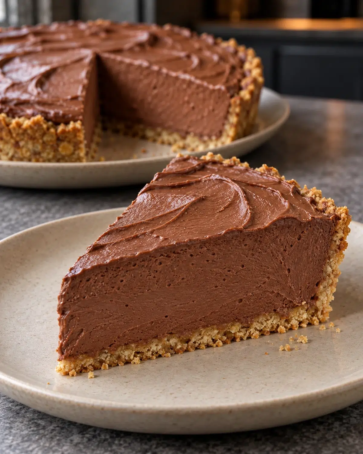 Slice of sugar-free French silk pie with a swirled chocolate mousse top and golden almond crust